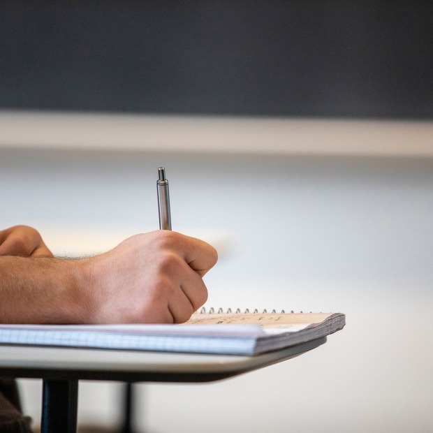 A hand writing in a notebook