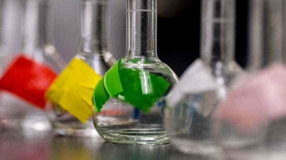 science beakers in a row with different colored tape