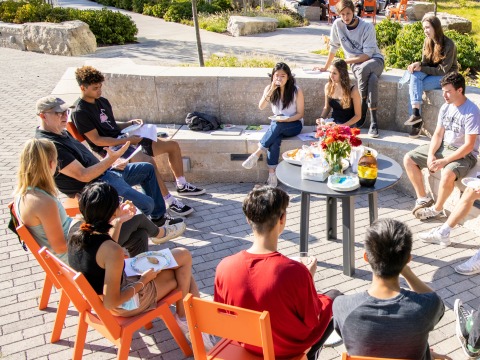 A group of students and their professor enjoy an outdoor class