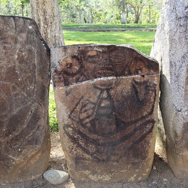 four weathered upright stones with petroglyphs of human figures