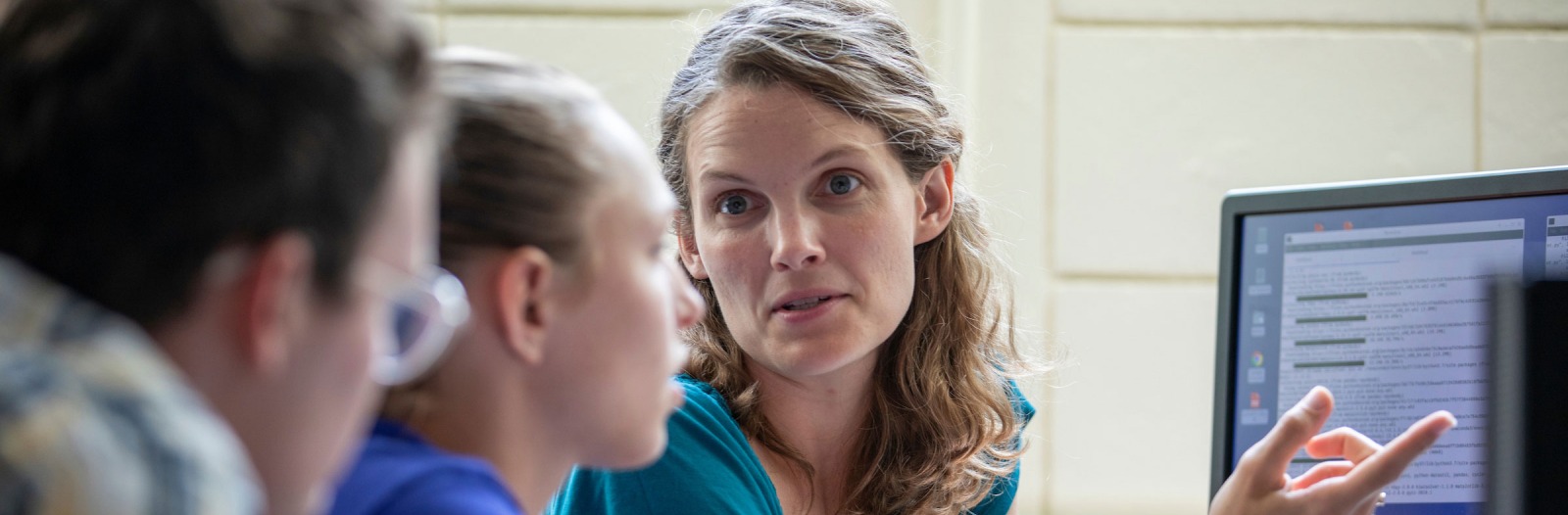 Charlotte Christensen looks over MAP work with Hollis Akins and  Anna Engelhardt