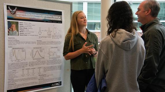 student presents research poster to faculty