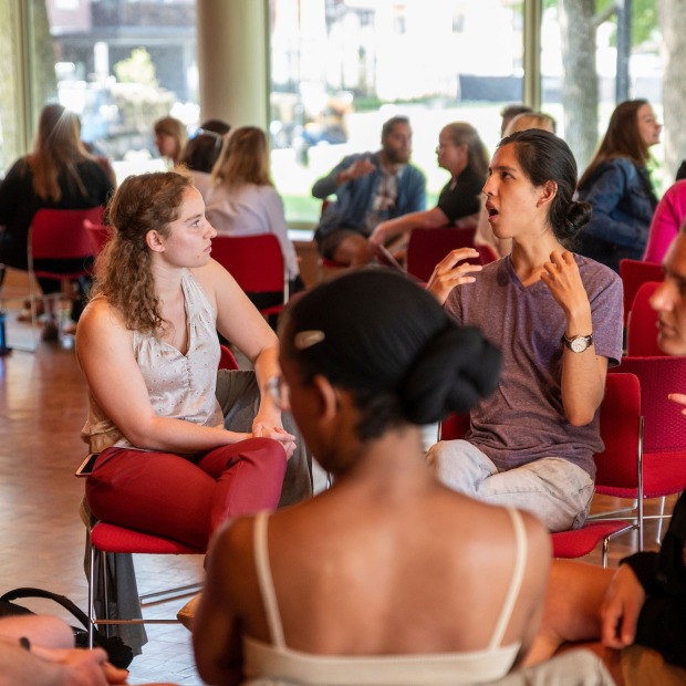 Two people engage in an animated discussion while in a community circle