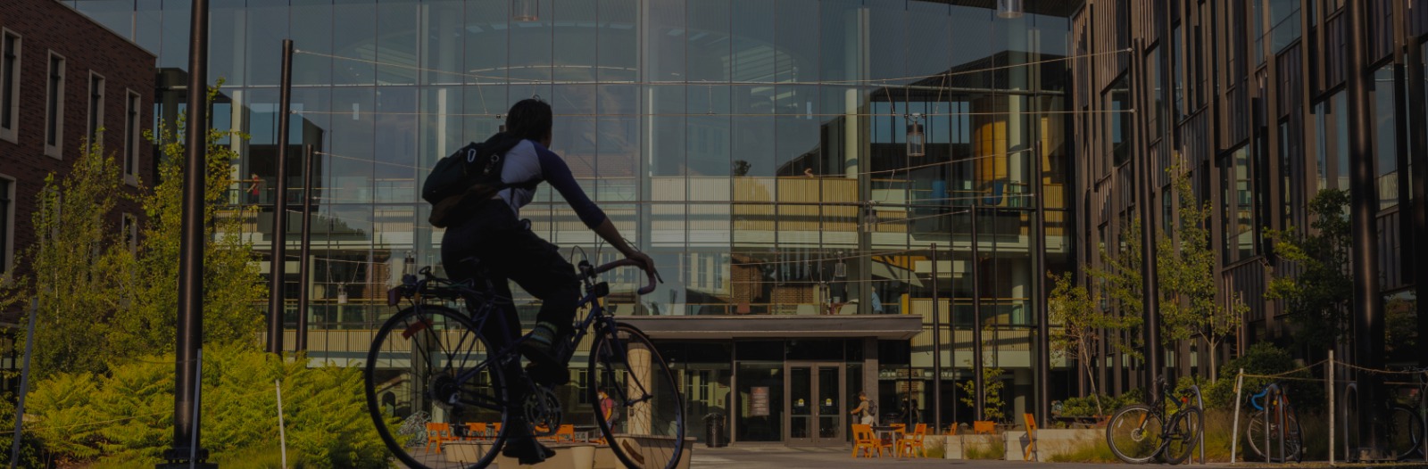 Student rides a bike around campus.