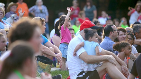 A crowd of families sitting on a lawn
