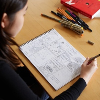 Sam Nakahira sketching a page for her book