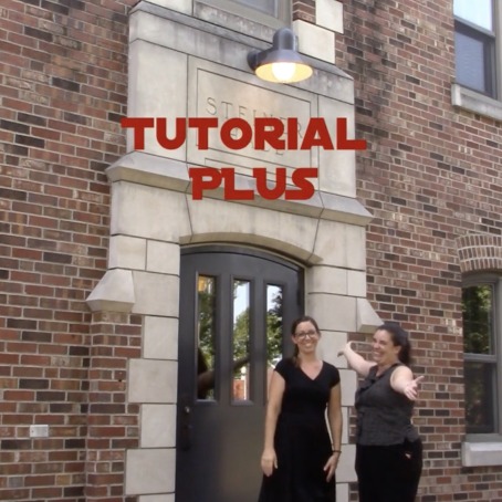 Two smile outside the entrance to an academic building
