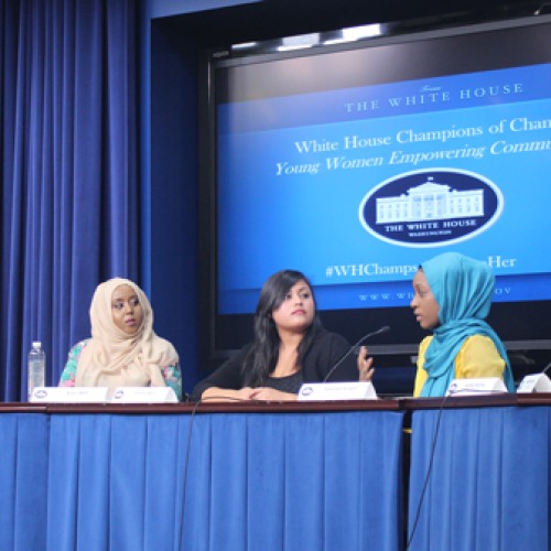 Yesenia Ayala sits at a table with five other women in front of a screen reading White House Champions of Change Young Women Empowering Communities.