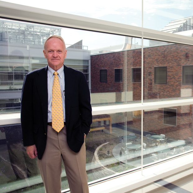Russell Osgood on a glassed in balcony overlooking a central courtyard
