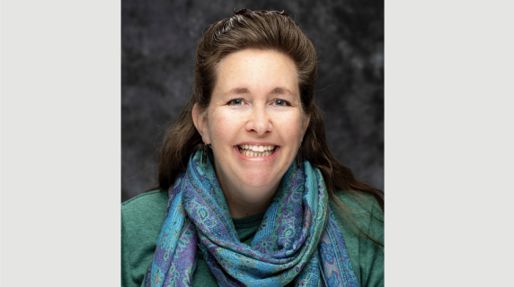 A woman smiles for a headshot