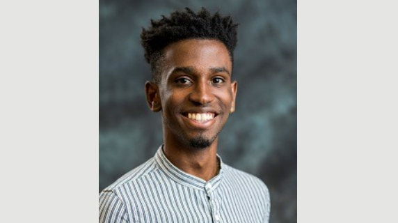 A man smiles for a headshot