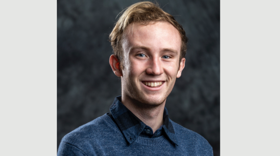 A man smiles for a headshot