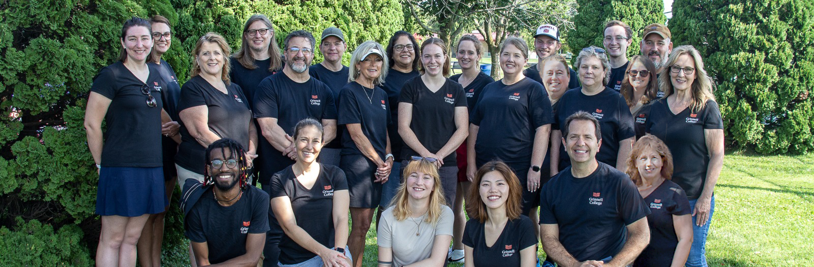 A group of enrollment professionals smile for the camera in matching black shirts