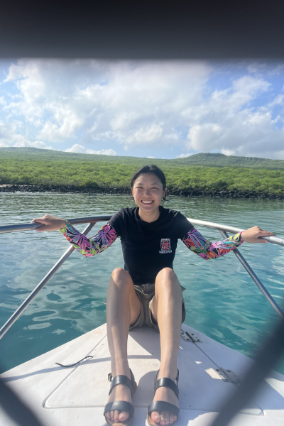 Mia smiles for the camera as she holds on to the boat railings