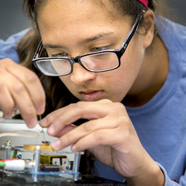 A student works with circuitry in a Grinnell Science Project lab