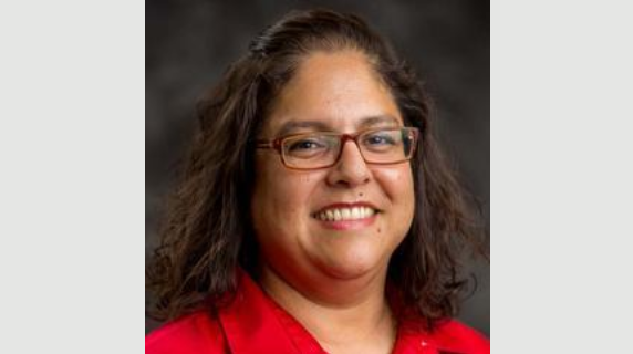 A woman smiles for a headshot