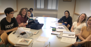 Students surround a table in a classroom