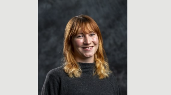A woman smiles for a headshot