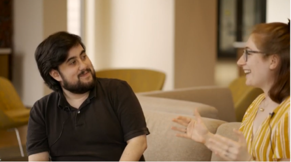 Ayyad and Maddy talking on a couch.