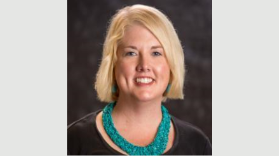 A woman smiles for a headshot